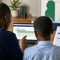 Parent and child checking a 2026/2027 Federal Unity Colleges JSS1 admission placement on a laptop