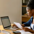 Nigerian female engineering undergraduate reviewing a scholarship application on a laptop